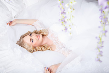 Obraz na płótnie Canvas photo of a beautiful blonde bride in a luxurious wedding dress in elegant expensive interior