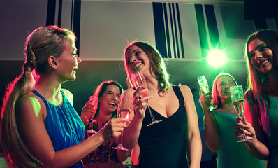 young women with glasses of champagne in club