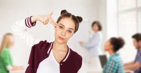 bored student girl making finger gun gesture