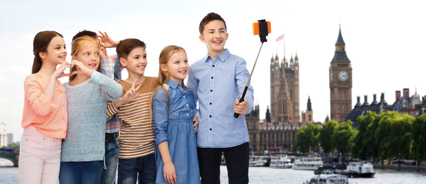 happy children with smartphone and selfie stick