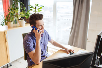 happy creative male worker calling on smarphone