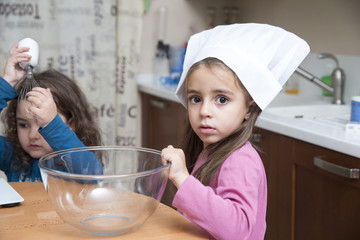 Portrait of cute girl in chef's hat looking at camera