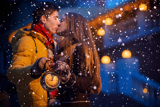 Couple with clock in winter night