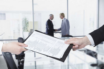 Businesswoman giving to businessman documents