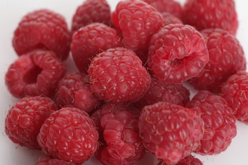 lot of red raspberry on white background