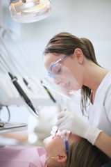 Closeup of a young dentist performing oral health hygiene