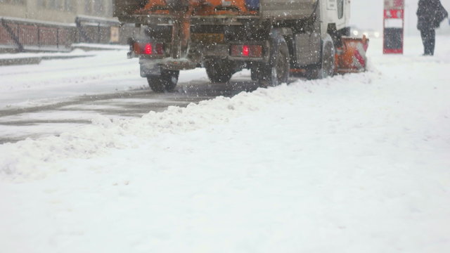 Back shot of plower cleaning up snow