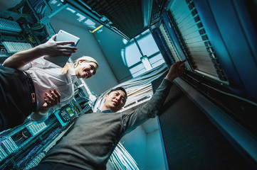 Young engineers businessmen in server room