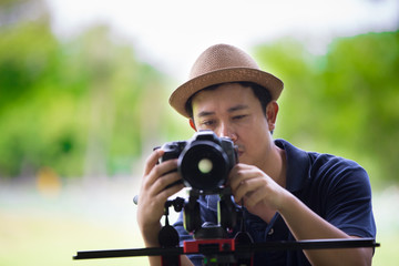 Obraz premium Thailand tourist sitting in park and watching pictures on his di