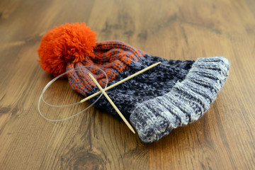 knitting wolly hat. finished hat on table. with needles