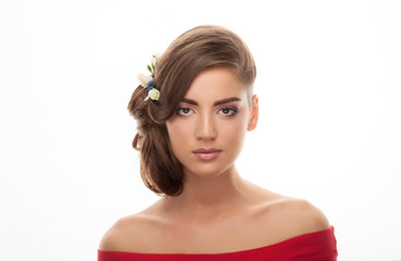 Closeup beauty portrait of young adorable brunette woman in red shirt with bare shoulders showing low bun hairstyle and trendy natural makeup on white studio background