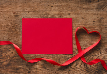 Happy Valentines Day. Red Ribbon Heart with red letter on a wooden background. Valentines Day concept