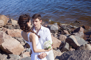 Just married happy couple on a rocky beach