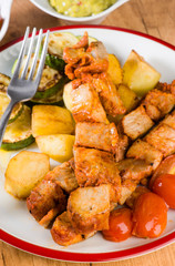 skewered meat and vegetables on wooden plate