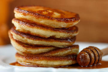 Breakfast. Fritters with honey  on a white plate.  Homemade pancakes
