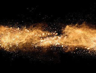 Explosion of orange powder on black background