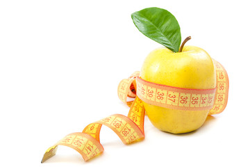 Fresh yellow apple and measuring tape