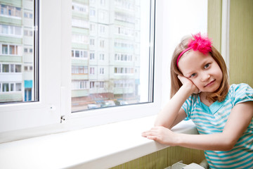 Fototapeta na wymiar Adorable little girl sitting by the window