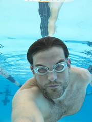 man swimming underwater, view from under water