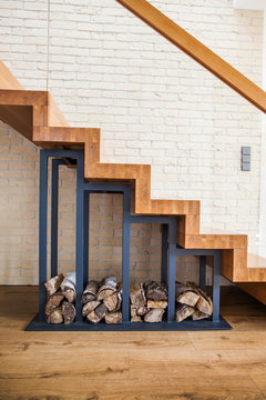 modern solution to storage pile of wood under the stairs at home 