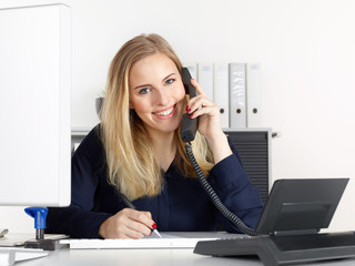 Female office assistant has a call at the office