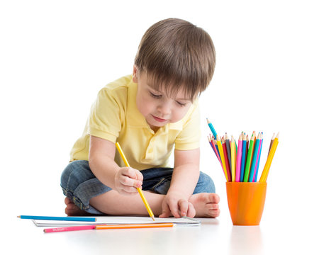 Cute child boy drawing with pencils in preschool isolated