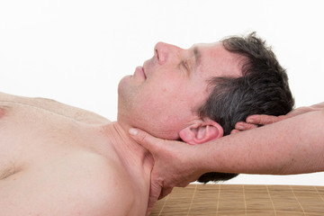 Therapist massaging the neck of woman while holding her head in a room