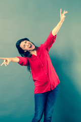 success concept - mad 30s woman laughing with wild body language for joy or satisfaction,studio shot, blue effects..