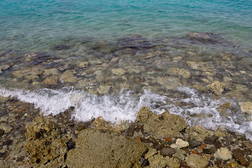Marine rocky shore with clear water and waves