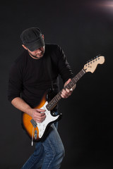 musician playing electric guitar on dark background