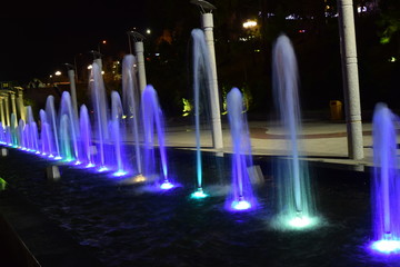 colorful fountain at night in a line