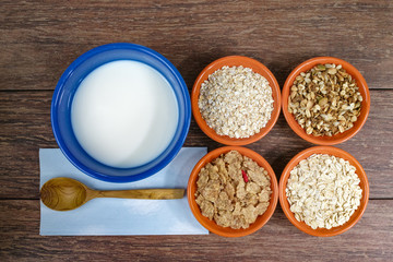 Four small bowls with different cereals and bowl with milk, healthy food, organic
