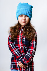 A little girl is in a funny cap. Studio photo