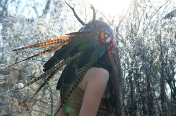 Indian-style girl in a horned hat is dancing tribal and shamanic