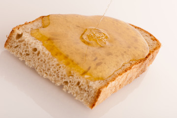 Sweet sticky golden honey on a slice of fresh bread.