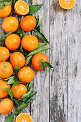 Fresh tangerines with leaves on a rustic wooden table.Selective focus. 