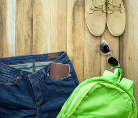 A Casual fashion outfit with passport on wooden background