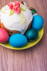 Traditional easter cake with glace icing  and colorful eggs on rustic table. Selective focus