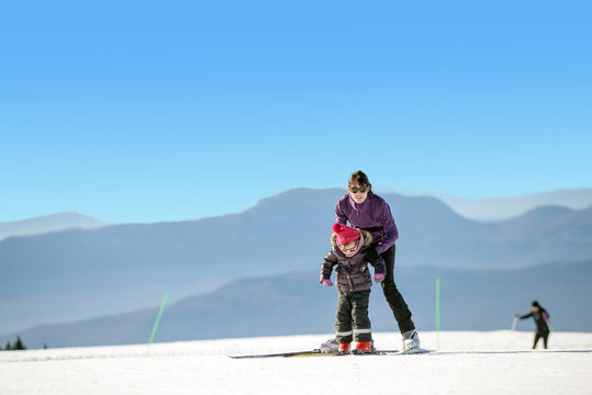 Young mother and daughter on ski vacation
