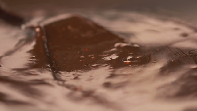 Stirring delicious melted chocolate with a knife in slow motion