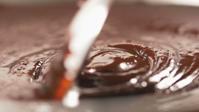 Stirring delicious melted chocolate with a spoon in slow motion