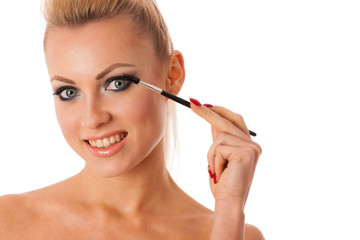 Fototapeta premium Portrait of woman holding beauty accessories, mascara, pauder br