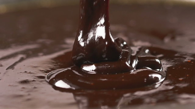 Delicious melted chocolate pouring in slow motion