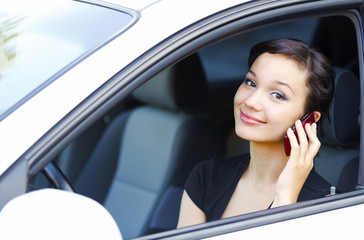 Woman sitting in a car and talking by mobile telephone