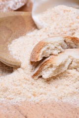 Bread crumbs on wooden table with spoon