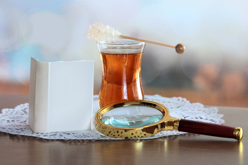 Mini book and magnifying glass on table