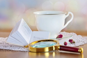 Mini book and magnifying glass on table