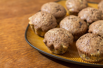 Two-color chocolate muffins in brown plate on wood table.