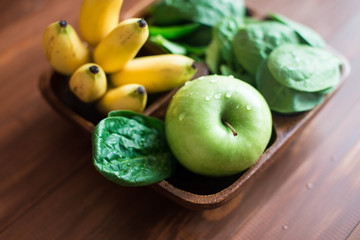 Fresh and organic green apple with spinach, bananas and pine nuts on rustic background. Healthy Still life 