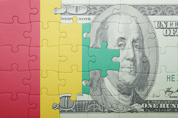 puzzle with the national flag of guinea and dollar banknote